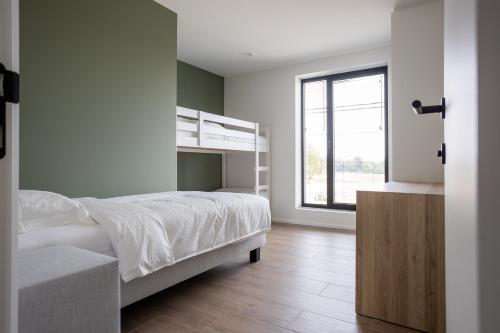a bedroom with a bunk bed and a window at NIEUW - De Grenspaal WEST 6P 5 min Maastricht - Sauna - Laadpaal in Riemst