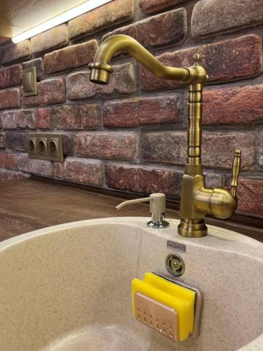 a bathroom with a gold faucet and a sink at River's house, very good location, free parking! in Sofia