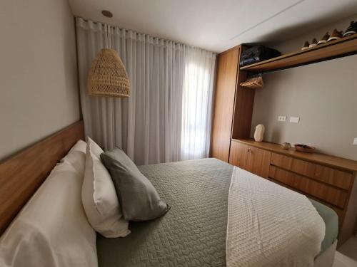 CairuにあるApartamento em Morro de São Paulo (BA)の白いシーツと枕が備わったベッドのある寝室