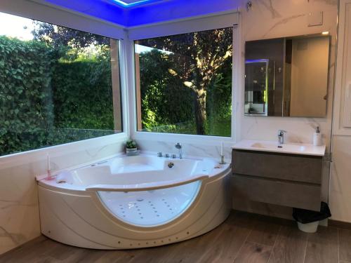 a large bathroom with a tub and a sink and a window at Villa Castro in Nuévalos