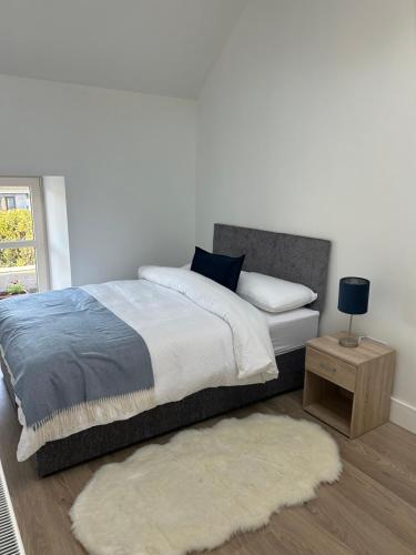 1 dormitorio con cama y mesa con alfombra en A Village Gem en Mullingar