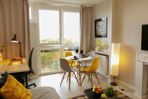 uma sala de estar com uma mesa e cadeiras e uma janela em Przechodnia 2 Yellow - Bezpłatny parking - Free parking - Biurko oraz wygodny fotel do pracy - Smart TV 42 cale - Wifi - Better Rental em Varsóvia