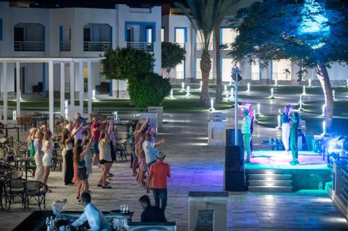 Un gruppo di persone che guardano uno spettacolo su un palco di Casa Blue Resort a Marsa Alam