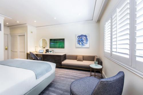 a bedroom with a bed and a couch at Mosaic Hotel Beverly Hills in Los Angeles