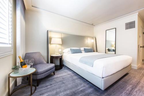 a hotel room with a bed and a chair at Mosaic Hotel Beverly Hills in Los Angeles