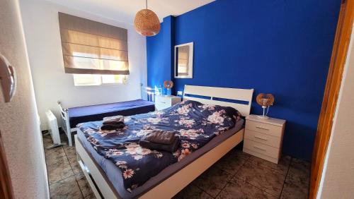 Un dormitorio azul con una cama y una pared azul. en Apartament Silvia, en Torrevieja