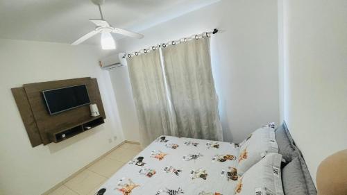 a small bedroom with a bed and a television at Apartamento praia Gravatá - Beto Carrero in Navegantes