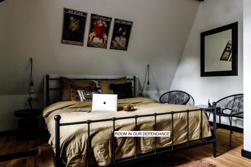 a bedroom with a bed with a laptop on it at Stella Suites Boutique Hotel in Goirle