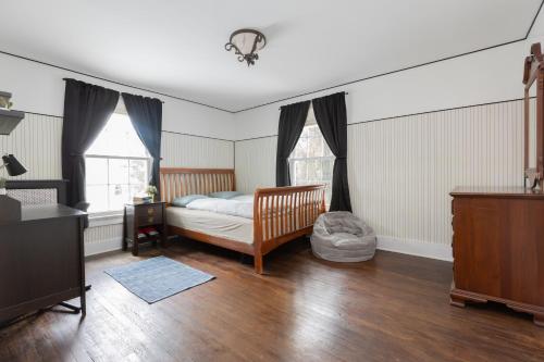 een slaapkamer met een bed, een bureau en ramen bij Entertainer's Luxury Retreat in Thomaston