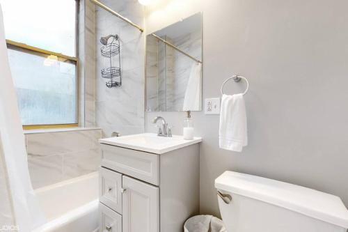 uma casa de banho branca com um lavatório e um WC em Chic Green l Near Downtown & IL Medical District em Chicago