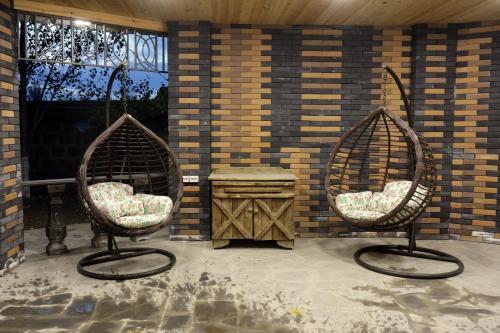 2 chaises assises sur une terrasse avec une table dans l'établissement Parvana Guest House, à Gyumri