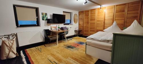 Schlafzimmer mit einem Bett und einem Schreibtisch mit einem TV in der Unterkunft Spacious & comfortable guestrooms w private bathrooms near Koelnmesse & Lanxess Arena, free parking, highspeed WiFi in Köln