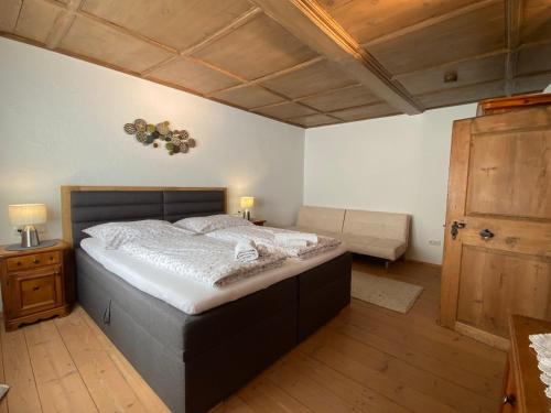 um quarto com uma cama grande e piso em madeira em Chalet Ida em Haiming