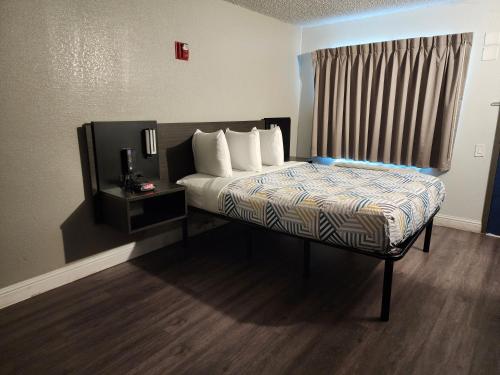 a bedroom with a bed with white pillows and a window at Studio 6 Sacramento, CA Natomas in Sacramento