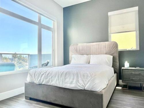 a bedroom with a bed with a large window at Designer Hollywood Penthouse with Private Balcony on Sunset in Los Angeles