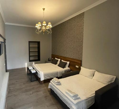 Habitación de hotel con 2 camas y lámpara de araña. en 2nd Floor Hotel en Tiflis