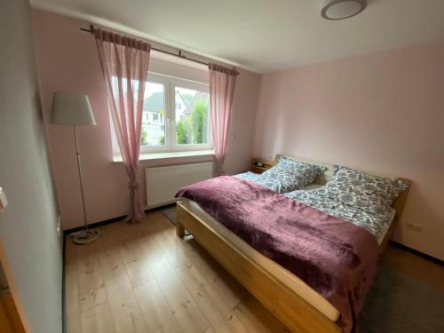 a small bedroom with a bed and a window at Ilmenau Lieblingsplatz in Lüneburg