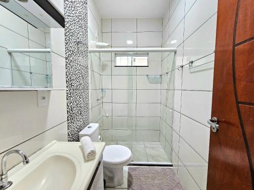 La salle de bains est pourvue de toilettes, d'un lavabo et d'une douche. dans l'établissement Lindo APT, prox Paraguai com Churrasqueira, à Foz do Iguaçu