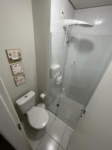a bathroom with a toilet and a glass shower at Travellar Spot 313B in Ribeirão Preto