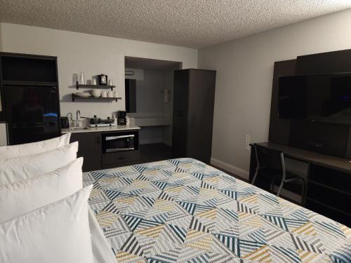 a hotel room with a bed and a flat screen tv at Studio 6 Sacramento, CA Natomas in Sacramento