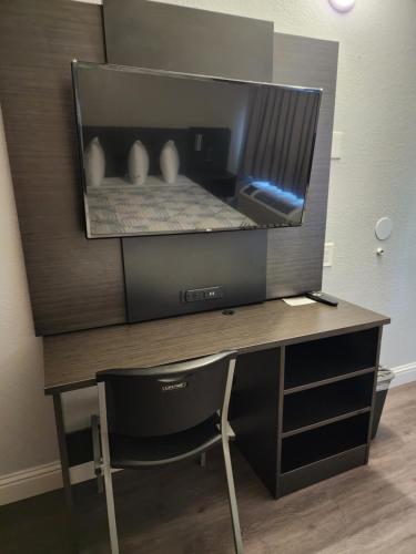 a desk with a monitor and a chair in a room at Studio 6 Sacramento, CA Natomas in Sacramento