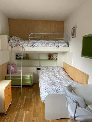 a small bedroom with a bunk bed and a desk at Appartamento la Regina del Lago in Molveno
