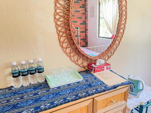 a counter with bottles of water and a mirror at Dusun Indah Cottage 2 in Bayan Lepas