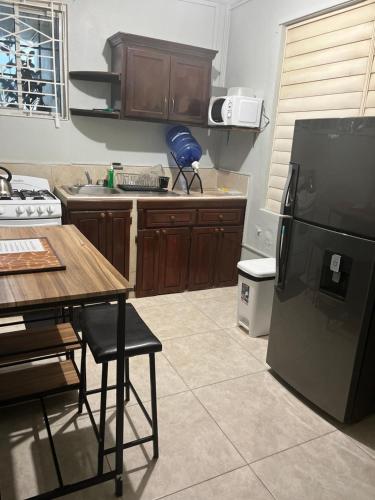 a kitchen with a black refrigerator and a table at Mona Master suite in Kingston