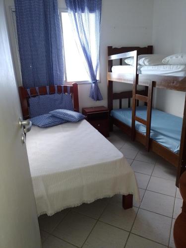 a bedroom with two bunk beds and a window at Espaço Sol, Mar & Cia in Bertioga