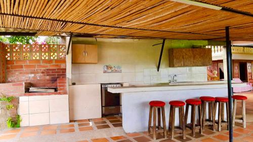 a kitchen with red stools at a kitchen counter at Mountain View Hostel in Manizales