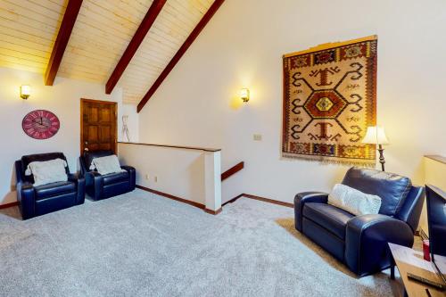 a living room with two blue chairs and a rug at Purgatory Perch in Durango Mountain Resort