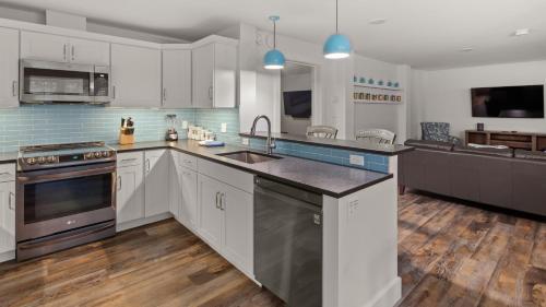 a large kitchen with white cabinets and a sink at La Pasta At Mad House condo in Warren