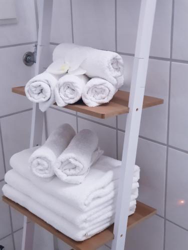 a stack of towels on a shelf in a bathroom at FeWo Goslar Harz in Goslar