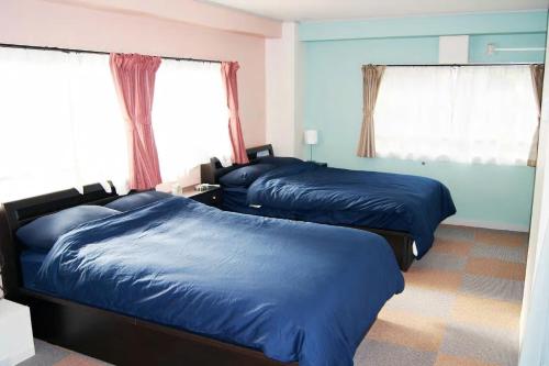 two beds in a bedroom with blue sheets at Space Air Building 3F - Vacation STAY 11441 in Tokyo