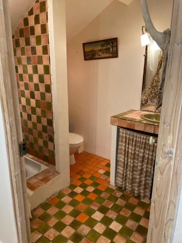 La salle de bains est pourvue d'un sol en damier et d'un lavabo. dans l'établissement LE 17, à Courthézon