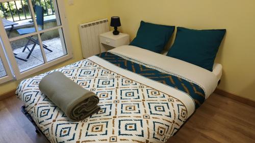 a bedroom with a bed with blue pillows at Bonvallet - Studio paisible et chaleureux avec balcon in Amiens