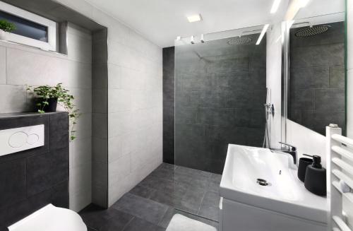 a bathroom with a white sink and a shower at Luxus apartmán pod hradom in Kežmarok