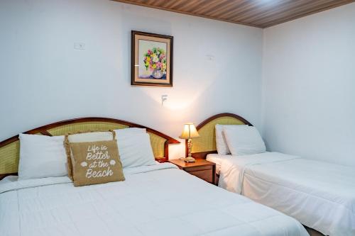 two beds in a hotel room with white sheets at Tropical Bliss Pool Wi-Fi BBQ Near Quepos Manuel Antonio in Quepos