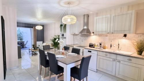 une cuisine et une salle à manger avec une table et des chaises dans l'établissement LE BAYARD Authentique Maison Sétoise Patio Climatisée Centre Historique Parking payant à proximité, à Sète