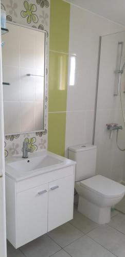 a bathroom with a toilet and a sink and a mirror at My sweet home in Paphos City