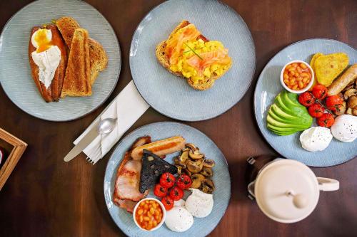 four plates of breakfast foods on a wooden table at Endeavour, Staithes in Staithes