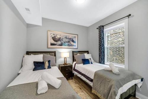 Forest Park的住宿－Spacious Haven 8-Min to Chicago Sleeps 10，一间卧室设有两张床和窗户。