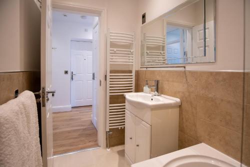 a bathroom with a toilet and a sink and a mirror at Sunny View in Scarborough
