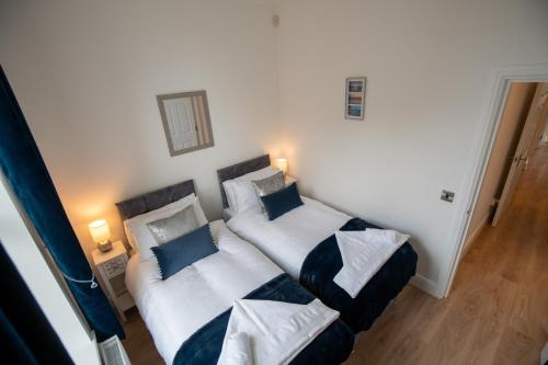 a bedroom with two beds with blue and white pillows at Sunny View in Scarborough
