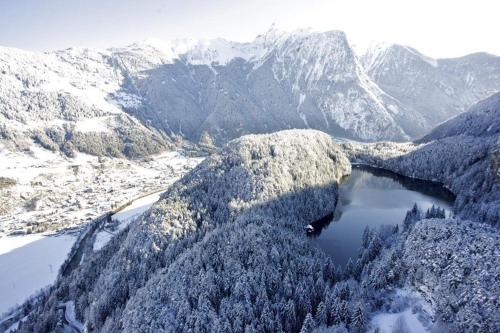 an aerial view of a snowy mountain range with a lake at Chalet Ida in Haiming