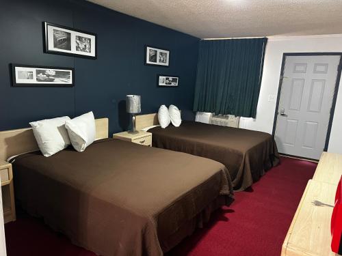 2 Betten in einem Hotelzimmer mit blauen Wänden in der Unterkunft country club inn in Colby