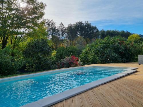 une grande piscine sur une terrasse en bois dans l'établissement Maison de vacances contemporaine, plein Périgord pourpre, à Sainte-Foy-de-Longas