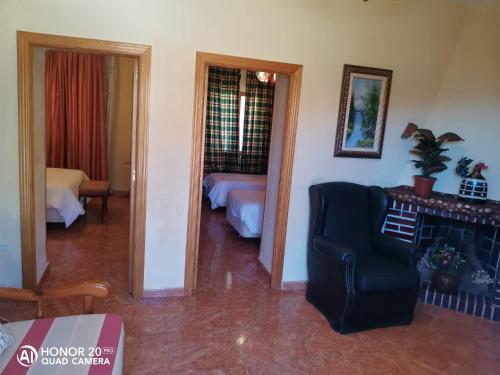 a living room with a room with a bed and a chair at Hotel Sierra Oriente in Guadarrama