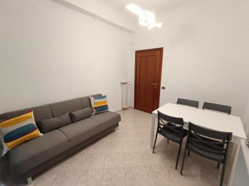 uma sala de estar com um sofá, uma mesa e cadeiras em Tia Tourist Apartment Rome em Roma