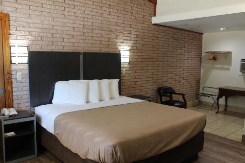 a bedroom with a bed and a brick wall at Evergreen Inn and R.V. in Winnfield